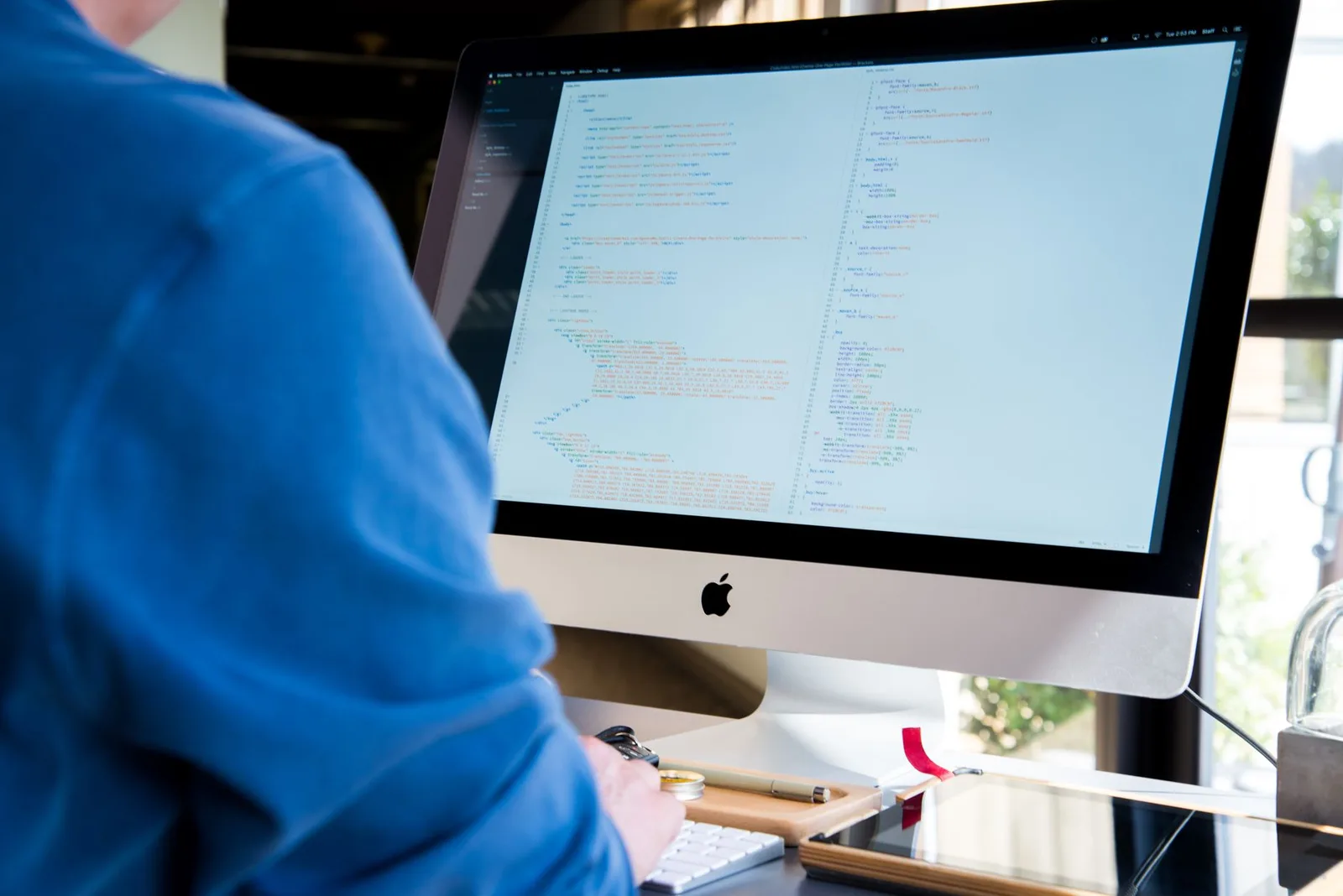 A developer writing code at a workstation